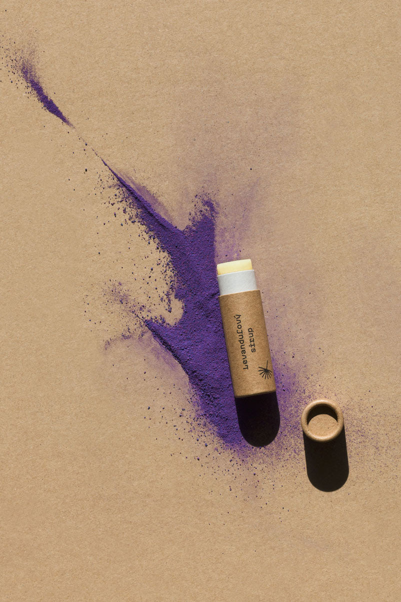 Prírodný balzam na pery Levanduľový sirup Modrá púpava s levanduľou na papierovom pozadí